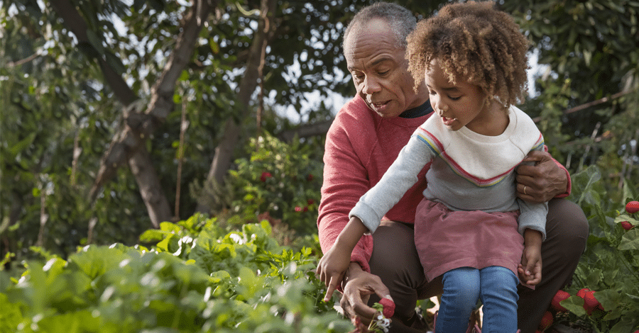 Older man and young girl in garden